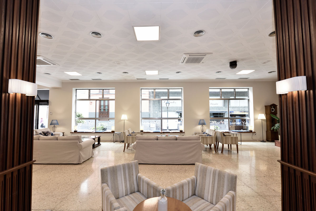 Woonkamer met fauteuils en lampen op Tenerife, met uitzicht op grote ramen.