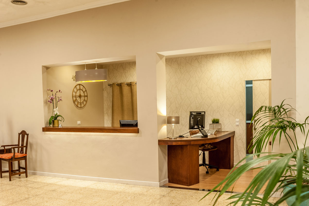Hotelreceptie op Tenerife met houten toonbank en computer.