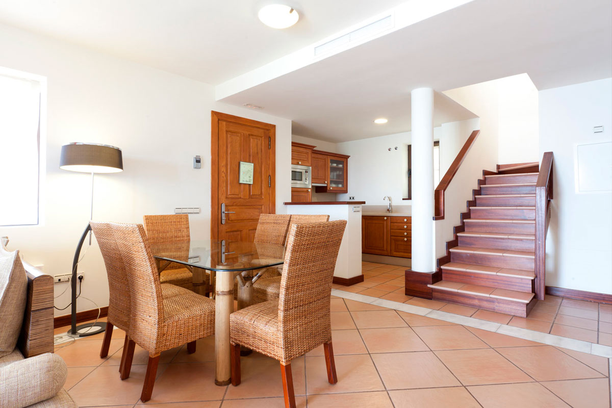 Eetkamer en trap thuis op Tenerife, keuken achterin.