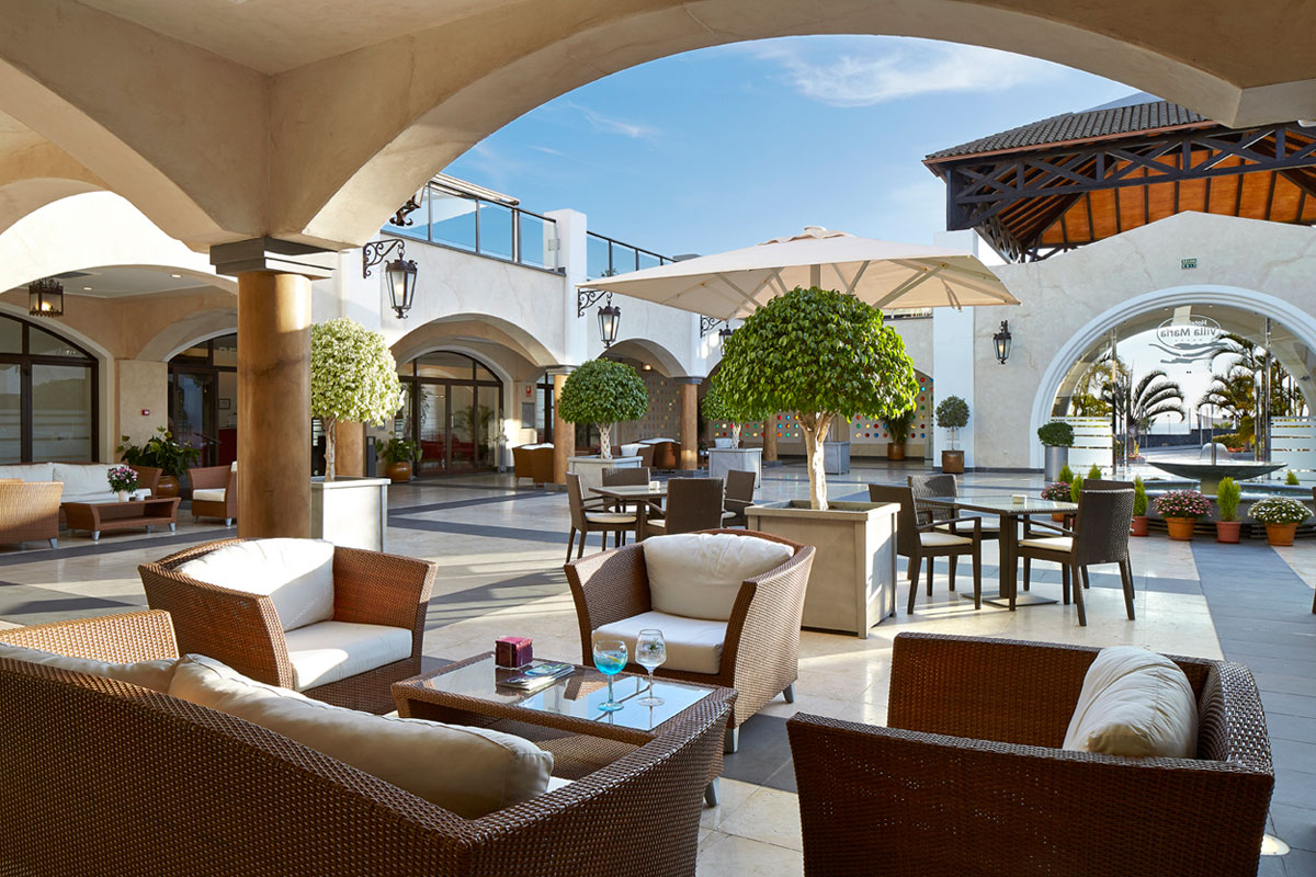 Terras met rotanmeubels en parasols, hotel op Tenerife.