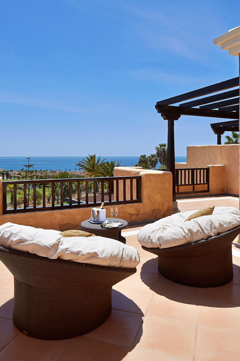 Terras met uitzicht op zee en tuinmeubilair in een hotel op Tenerife.