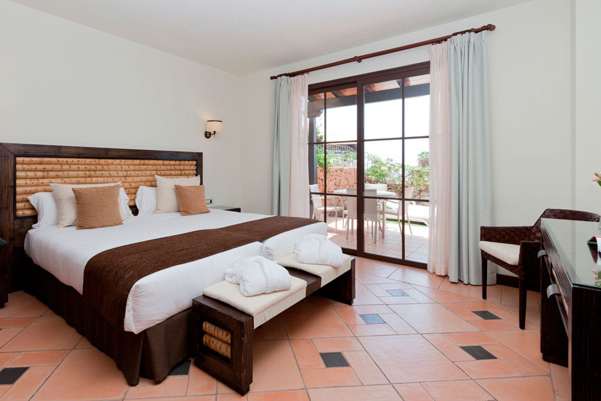 Kamer met groot bed, ramen en terras in een hotel op Tenerife.