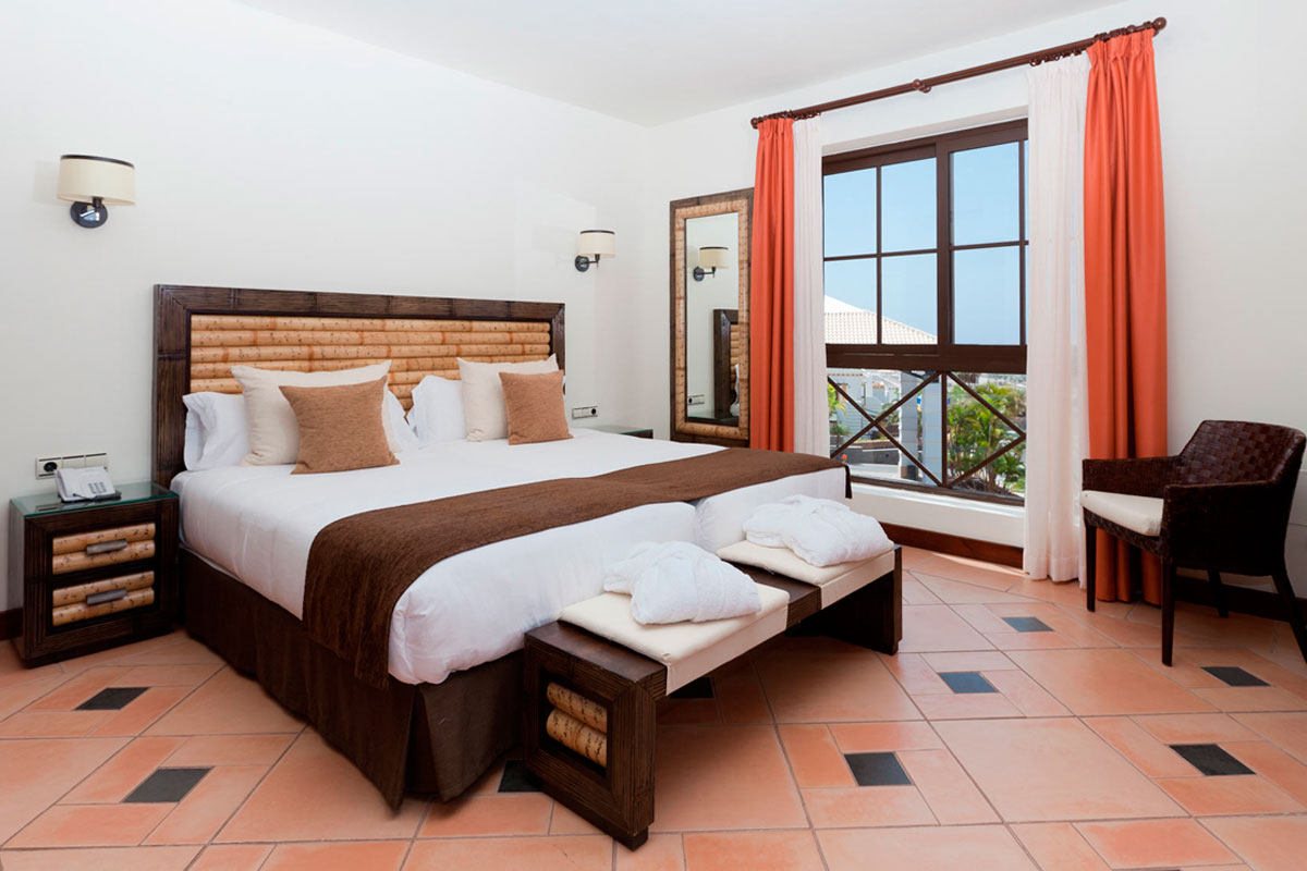 Dubbele kamer met open raam en oranje gordijnen, Tenerife.