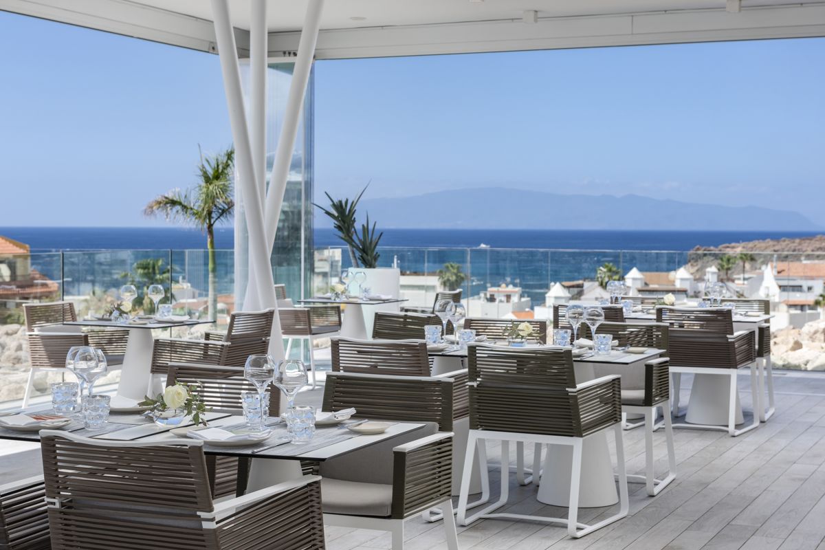 Restaurantterras met uitzicht op zee op Tenerife, tafels klaargemaakt voor de bediening.