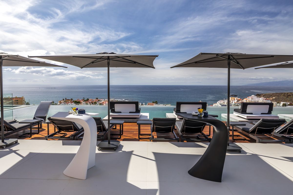 Terras met ligstoelen en parasols met uitzicht op zee op Tenerife.