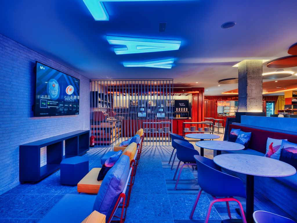 Verlichte rustplaats in de bar van Tenerife met scherm en tafels.
