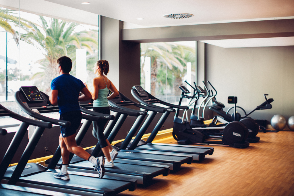 Mensen die op loopbanden van de sportschool rennen op Tenerife, interieuraanzicht.