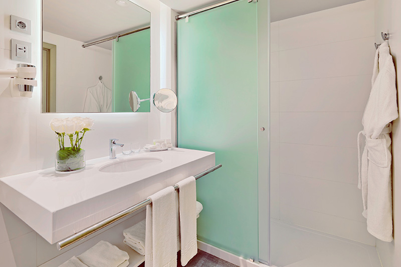 Moderne badkamer met wastafel, douche en handdoeken in het hotel op Tenerife.
