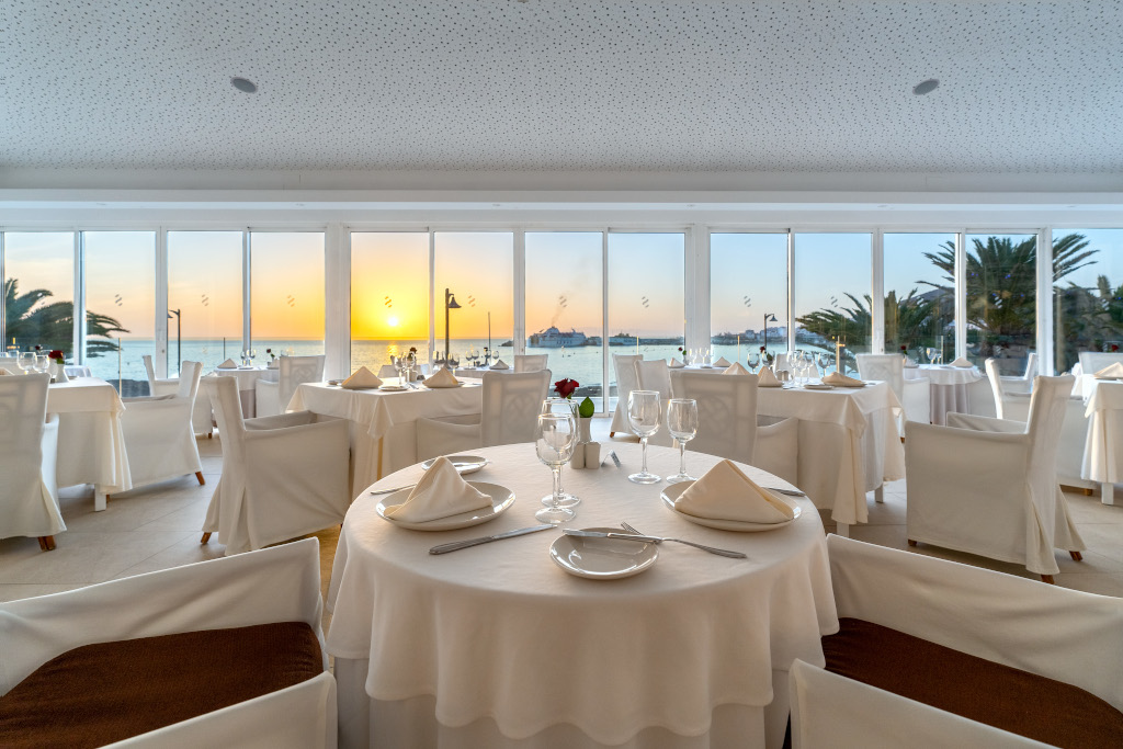 Restaurant met elegante tafels en uitzicht op de zonsondergang op Tenerife.