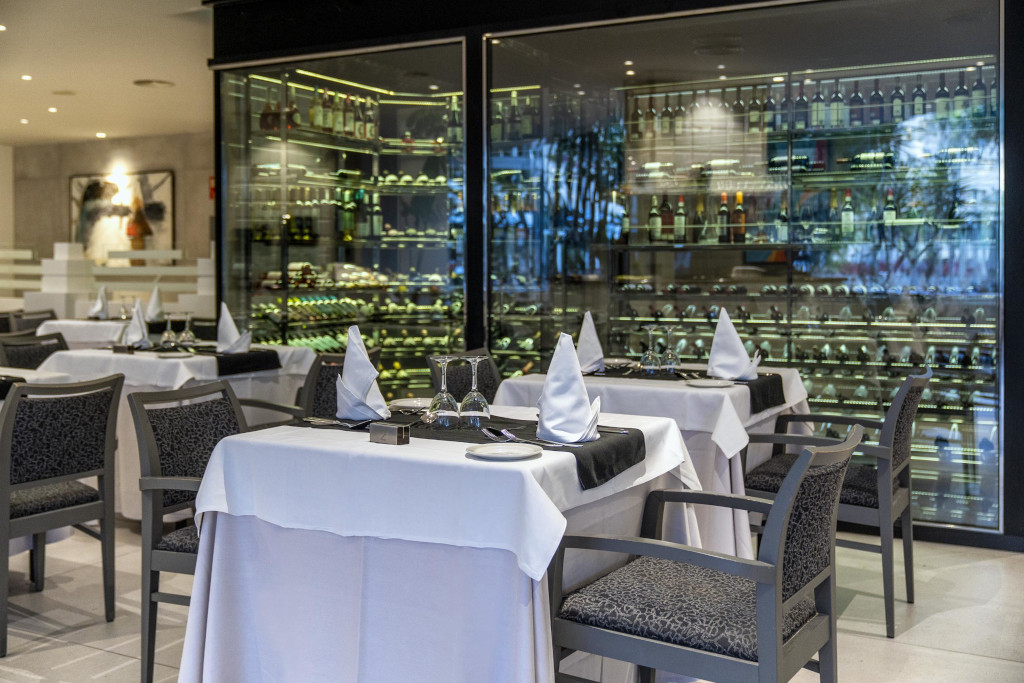 Elegant restaurant op Tenerife met gedekte tafels en flessen wijn op de achtergrond.