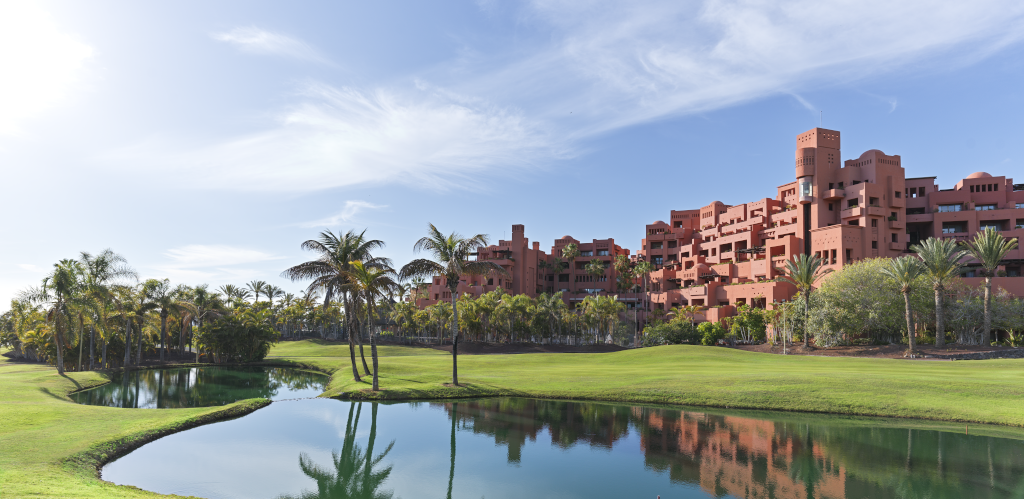 Hotel met unieke architectuur, omgeven door palmbomen en een meer op Tenerife.