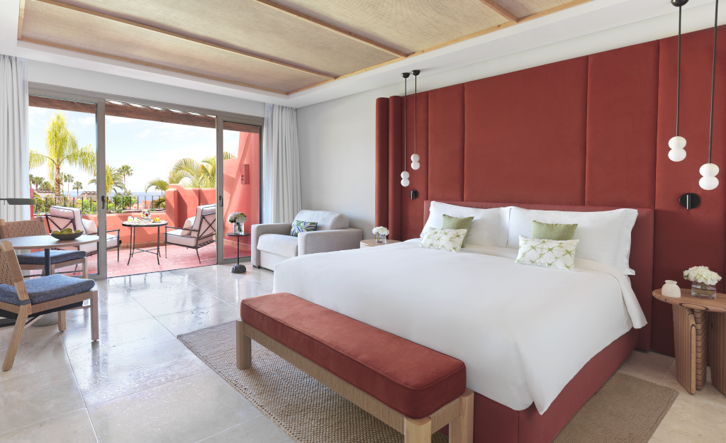 Hotelkamer op Tenerife met een tweepersoonsbed en terras met uitzicht op palmbomen.