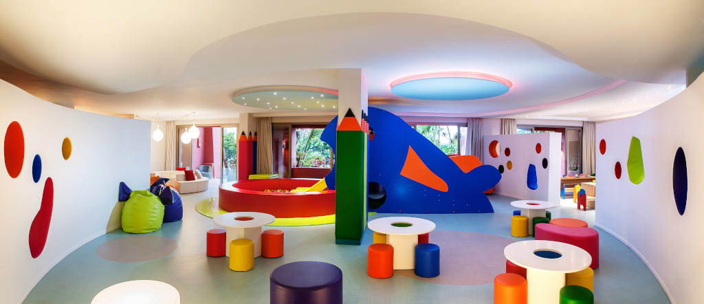 Kleurrijke kinderspeelkamer in een hotel op Tenerife met tafels en kussens.