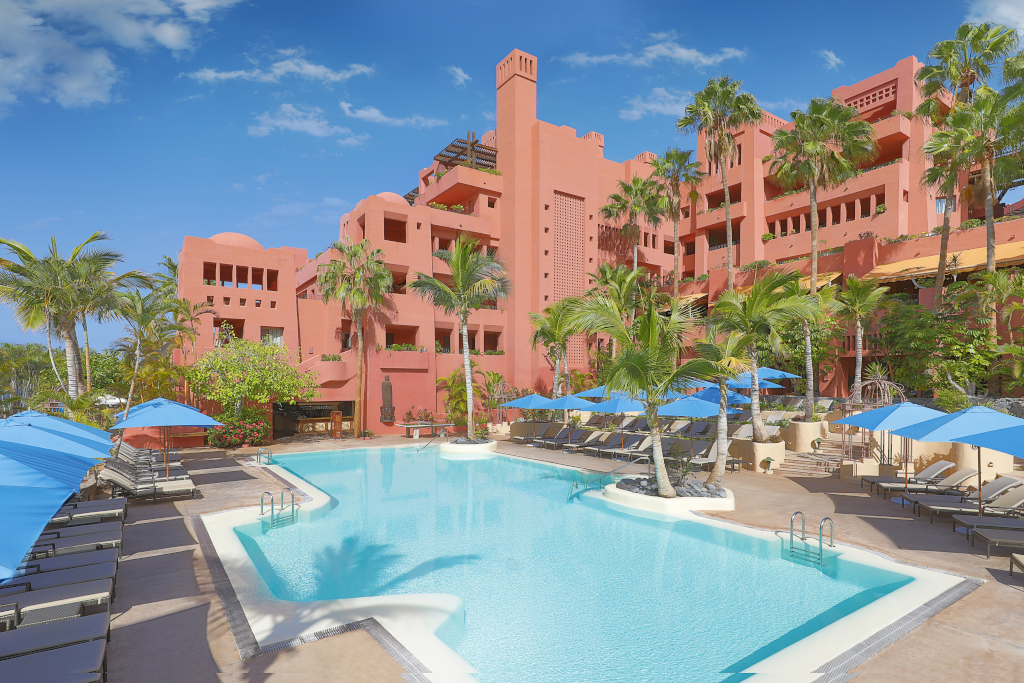 Zwembad omringd door ligstoelen en parasols bij een resort op Tenerife.