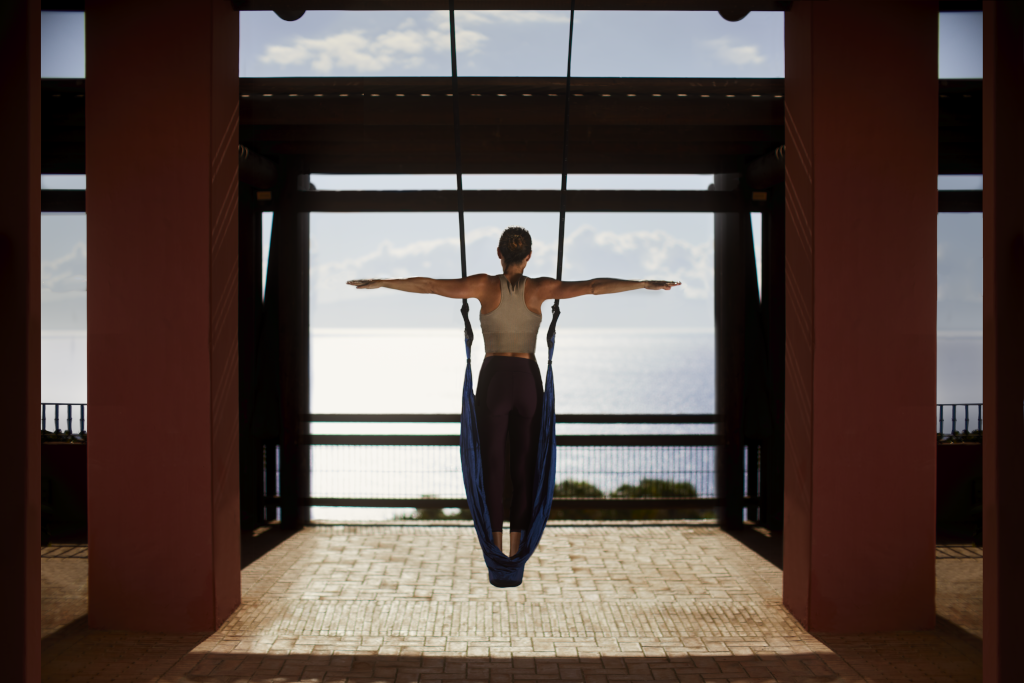 Persoon die luchtyoga beoefent voor de zee op Tenerife.