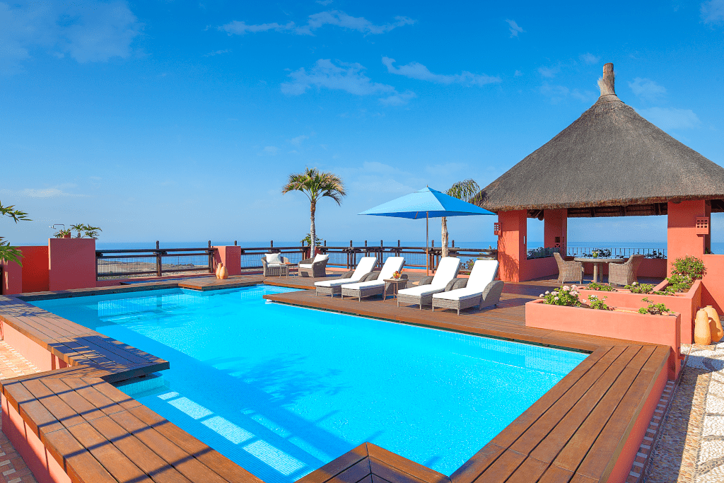 Zwembad met parasols en stoelen aan de oceaan op Tenerife.