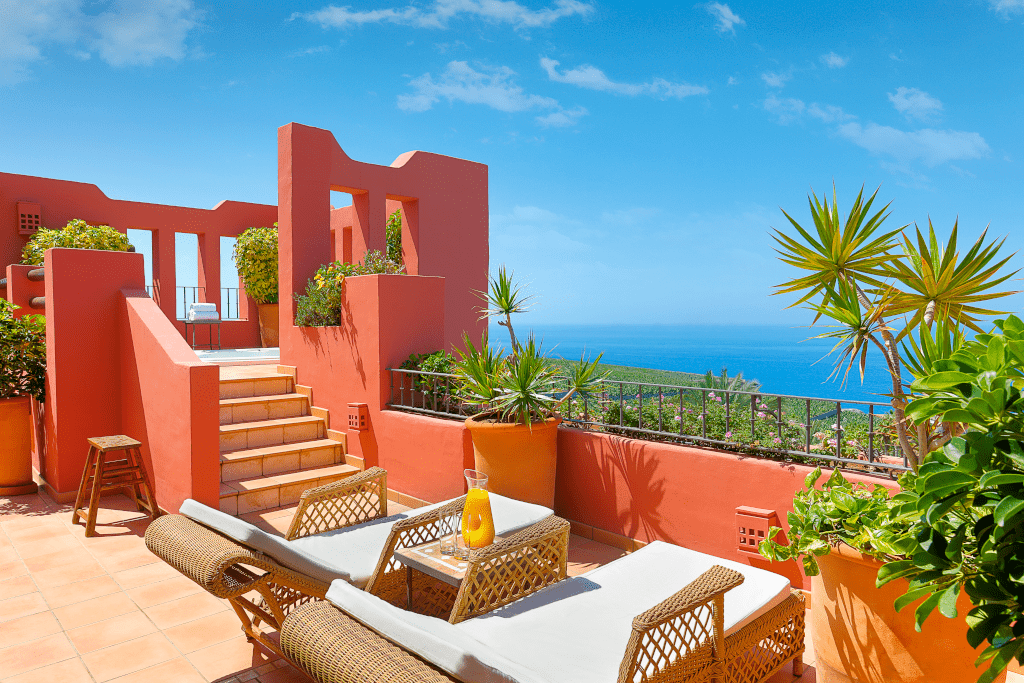 Terras met zeezicht op Tenerife, met ligstoelen en planten.