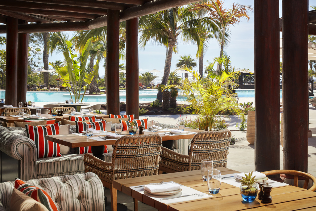 Restaurantterras met uitzicht op het zwembad en de palmbomen op Tenerife.