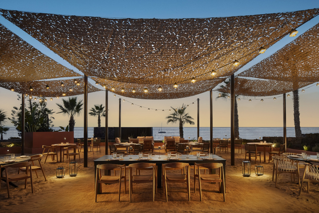 Openluchtrestaurant op Tenerife met zeezicht bij zonsondergang.