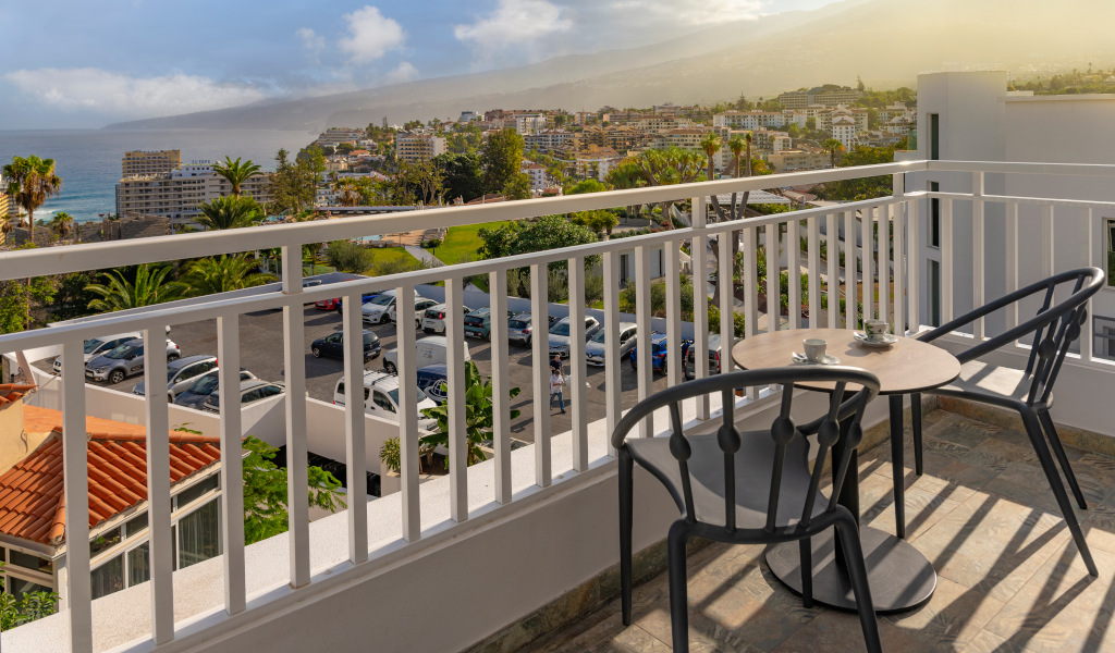Terras met tafel en stoelen, uitzicht op zee en stad in Puerto de la Cruz, Tenerife.