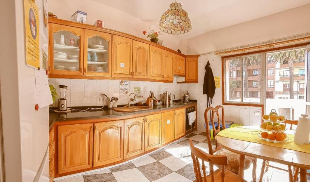 Keuken met houten meubels en groot raam in Tenerife.