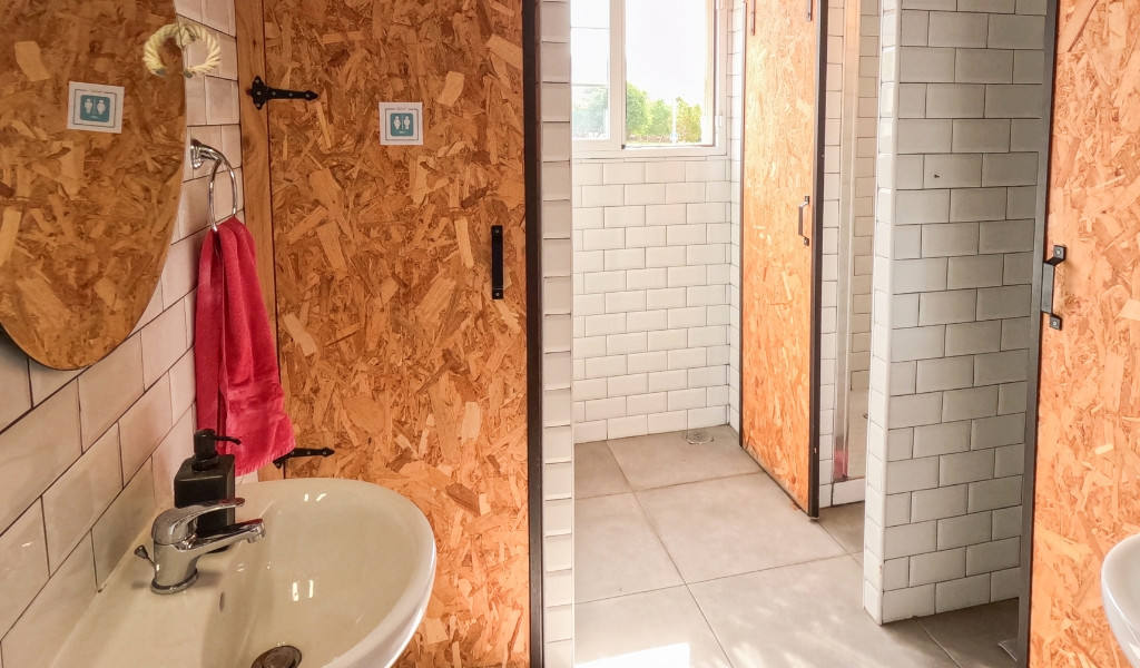 Badkamer met wastafel, spiegel, roze handdoek en houten deuren op Tenerife.