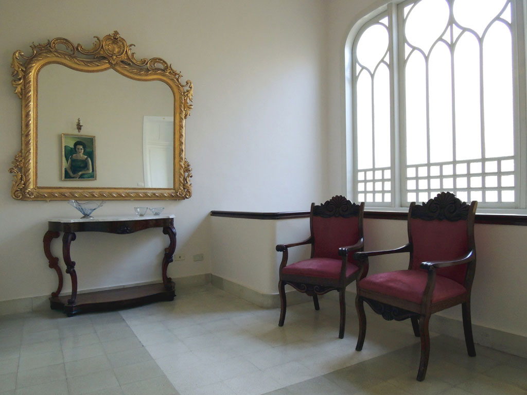 Gouden spiegel, schilderij en stoelen in een verlichte kamer op Tenerife.