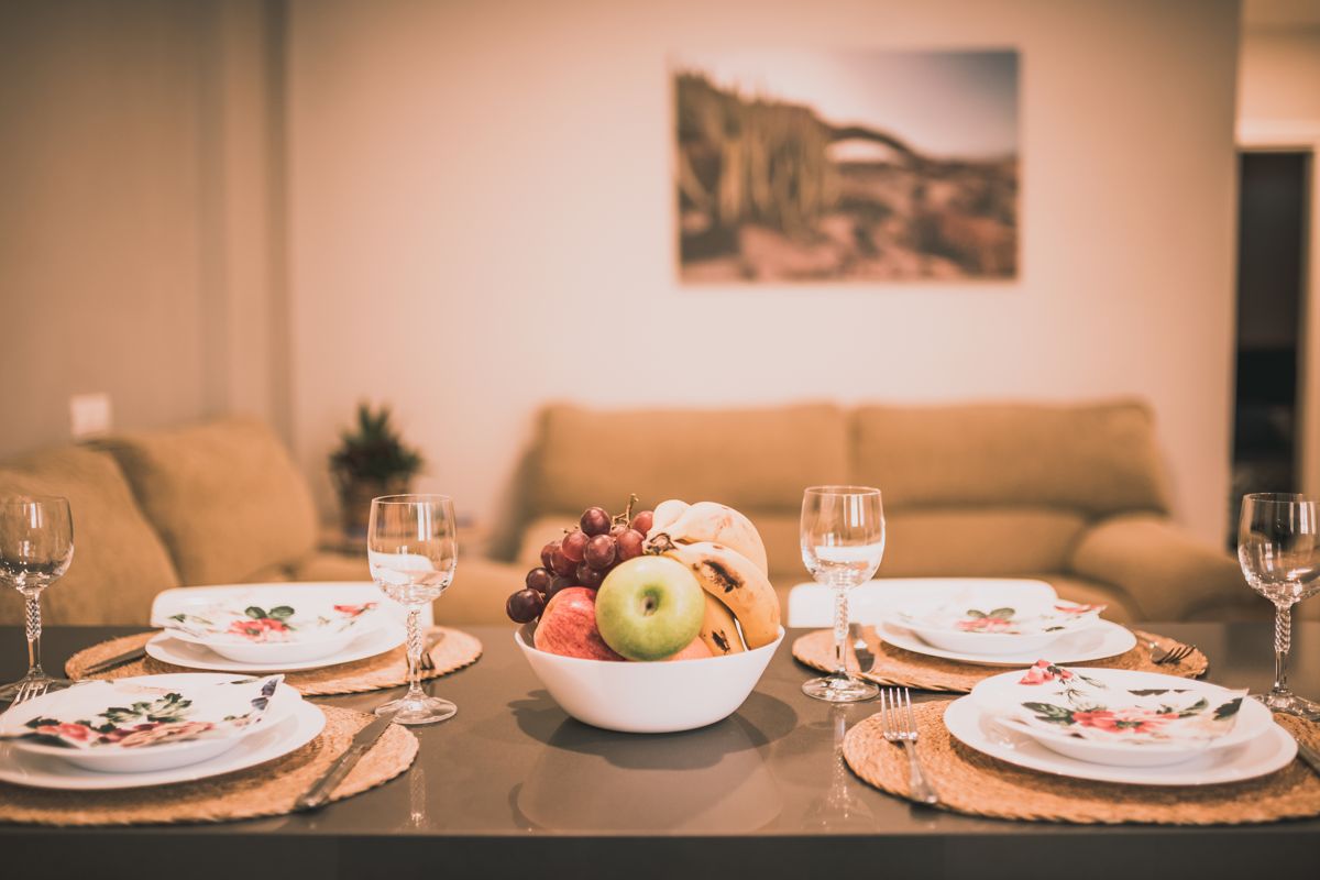 Tafel met decoratieve borden en een middelpunt met fruit in een woonkamer op Tenerife.
