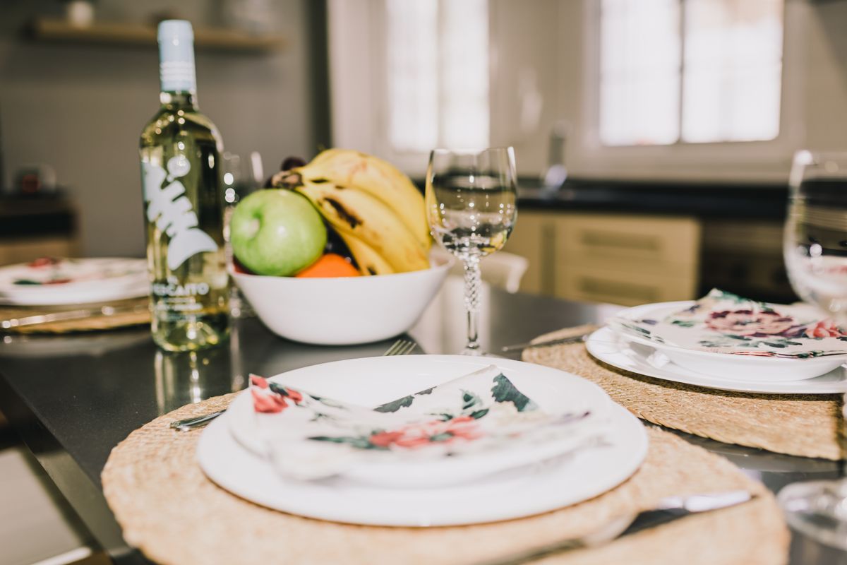 Fles witte wijn en fruitkom met bananen en appel in de Tenerife-keuken.