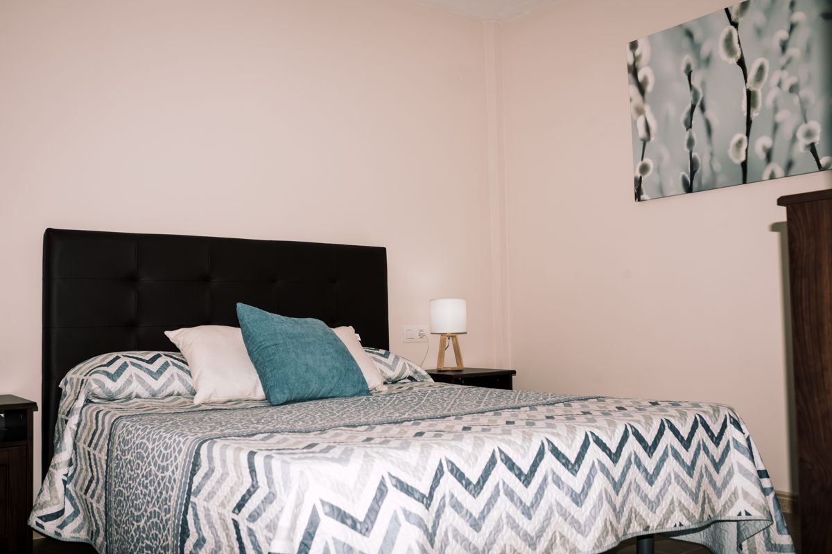 Kamer met een dubbel kussenbed en een hoektafellamp op Tenerife.