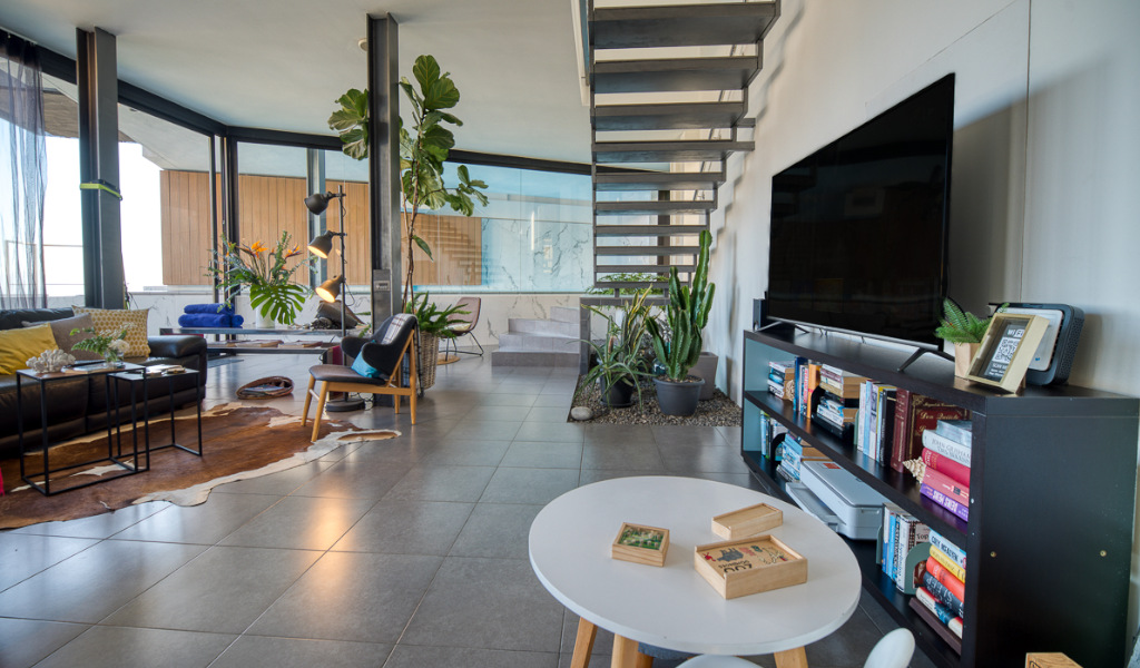 Moderne woonkamer op Tenerife met trap en grote tv.