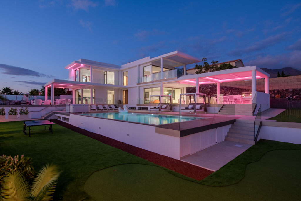 Modern huis verlicht bij schemering met een zwembad op Tenerife.