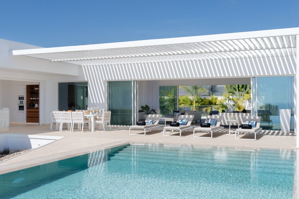 Modern terras met zwembad, tafels en ligstoelen in een villa op Tenerife.