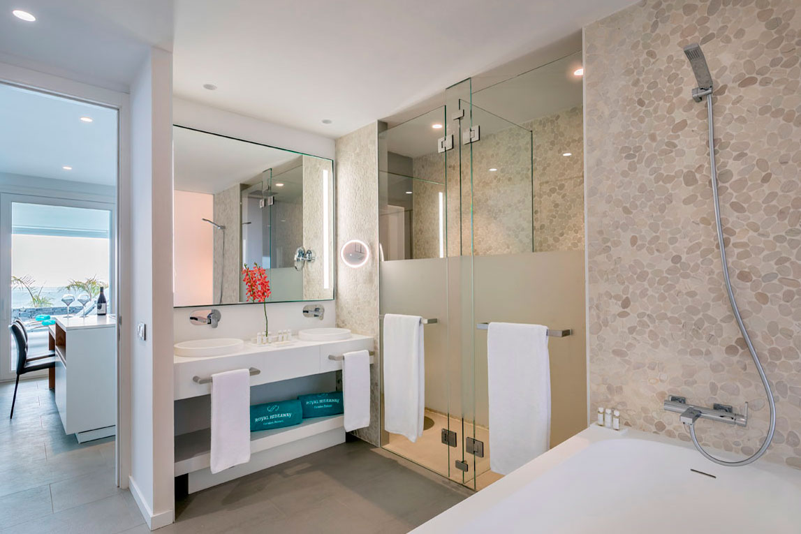 Moderne badkamer met glazen douche en dubbele wastafel in een hotel op Tenerife.