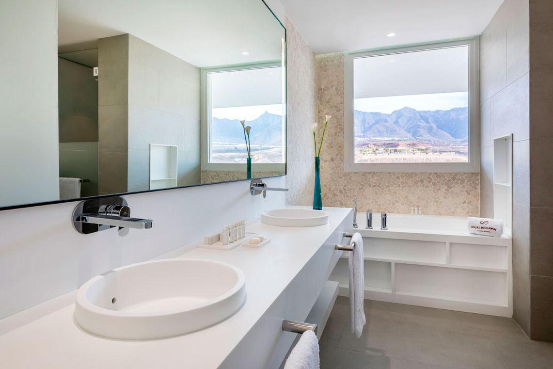 Moderne badkamer met dubbele wastafel en raam met uitzicht op Tenerife.