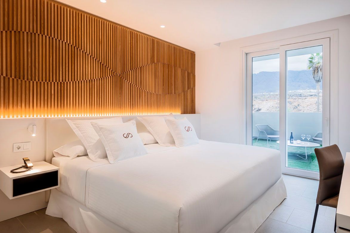 Hotelkamer op Tenerife met tweepersoonsbed, terras en uitzicht naar buiten.