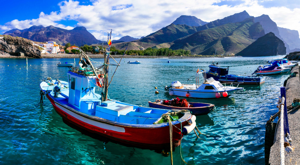 Vissersboten in de haven van Agaete, Tenerife, met bergen op de achtergrond.