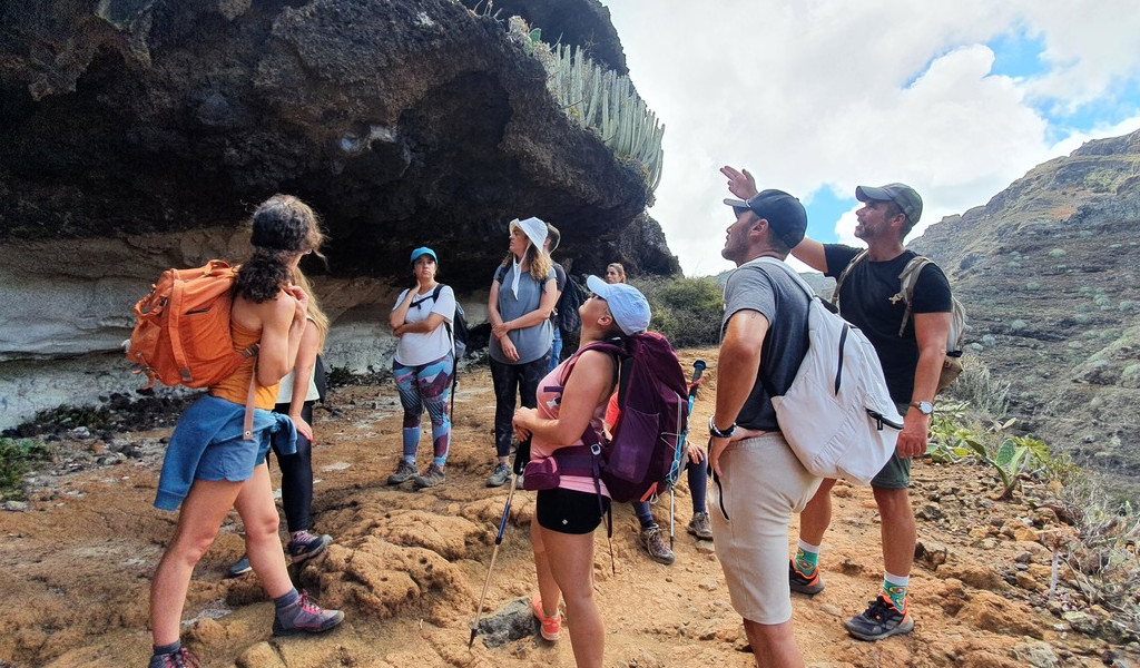 Groep wandelaars op een bergpad op Tenerife, terwijl ze het rotsachtige landschap observeren.