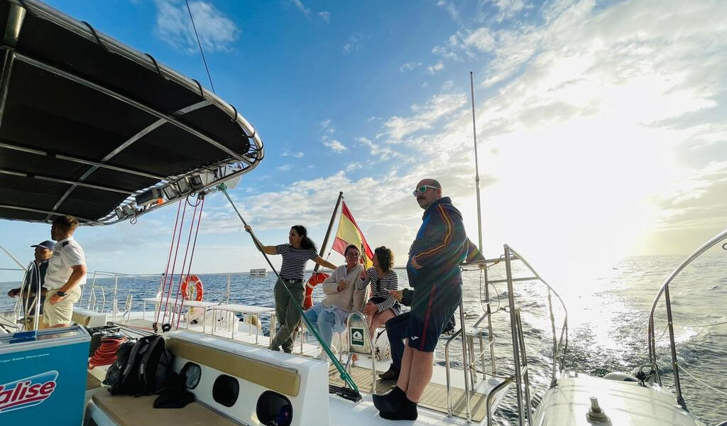 Mensen die bij zonsondergang met een boot varen voor de kust van Tenerife.