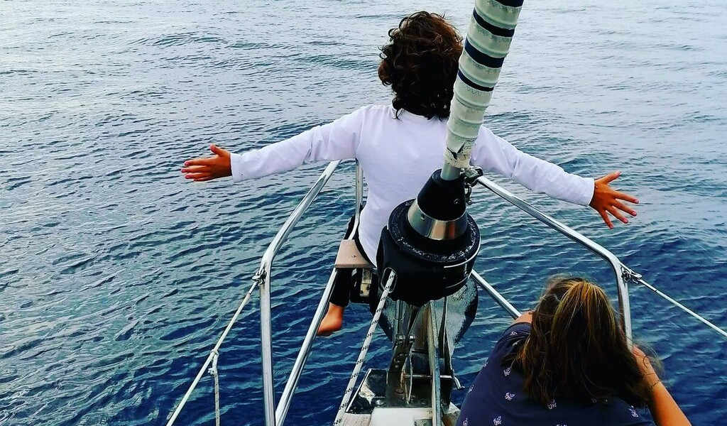 Kinderen die genieten van de boeg van een zeilboot op de zee van Tenerife.