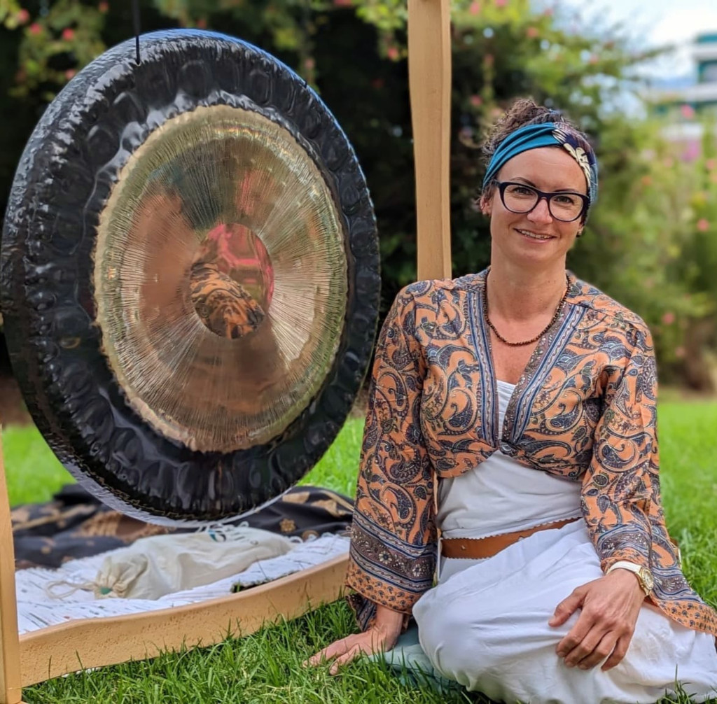 Persoon die naast een gong zit in een tuin op Tenerife.