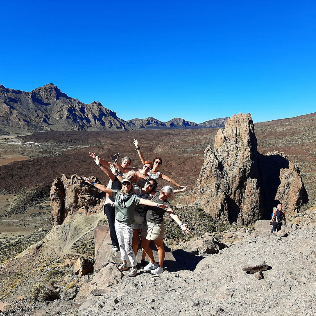 Groep mensen poseert voor het rotsachtige landschap van de berg Teide op Tenerife.
