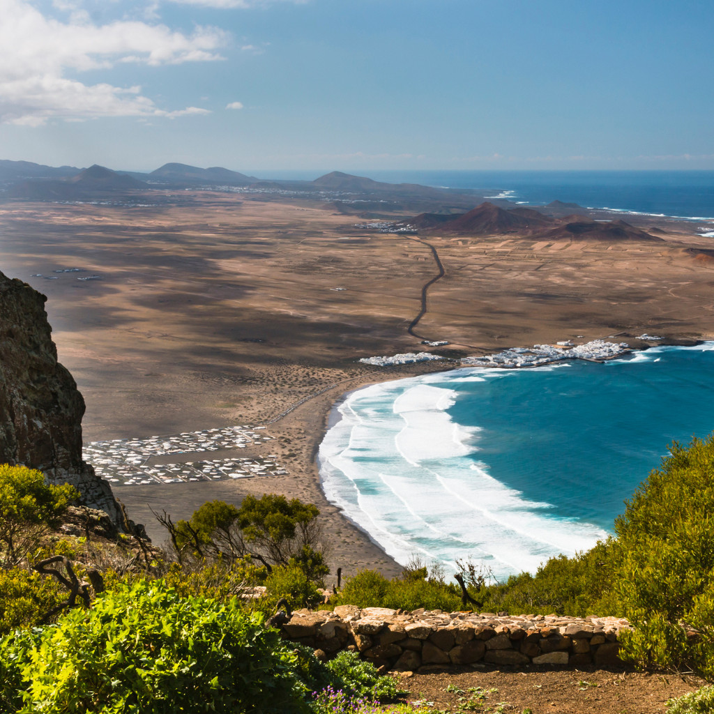 Panoramisch uitzicht op de kust met golven die slaan op een zandstrand op Tenerife.