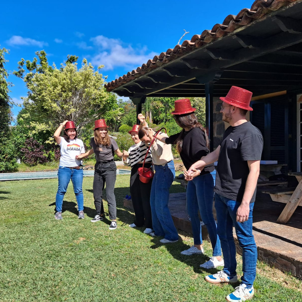 Groep mensen met rode hoeden in de tuin van een huis op Tenerife.
