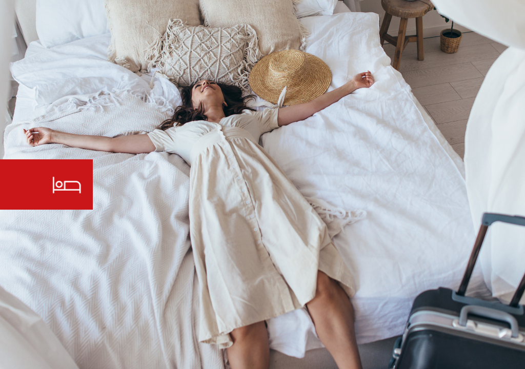 Iemand die op een bed rustte naast een koffer en een hoed op Tenerife.