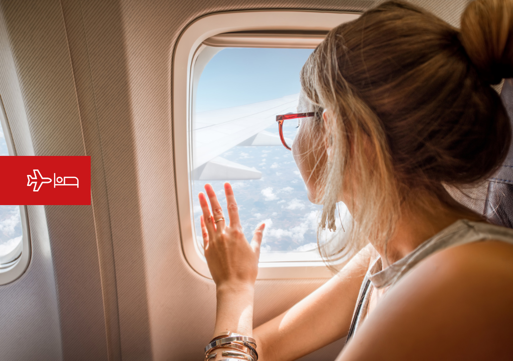 Vrouw kijkt uit het raam van het vliegtuig op weg naar Tenerife.
