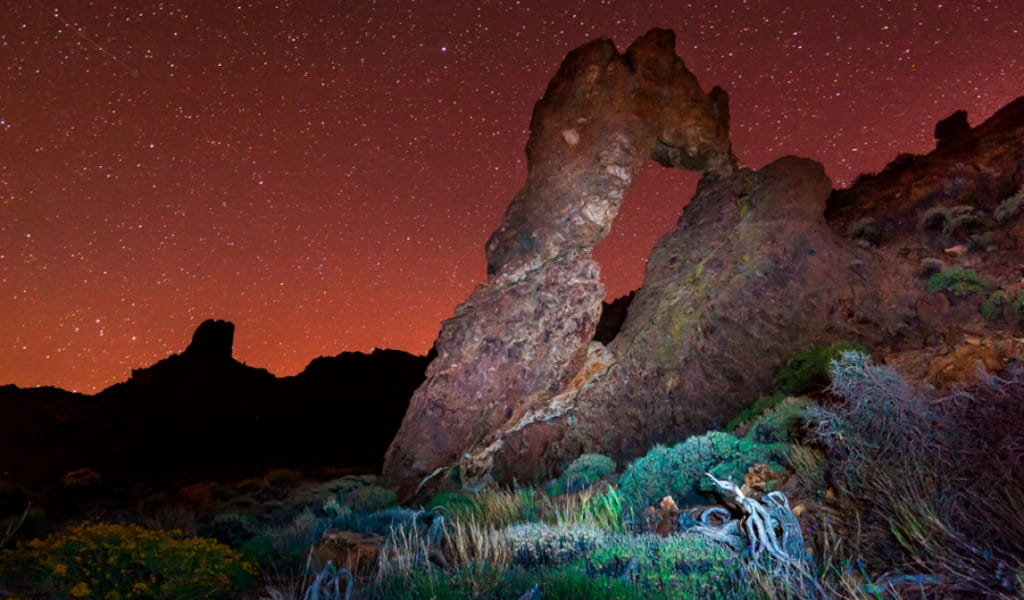 Boogvormige rots onder een sterrenhemel in het Nationaal Park Teide, Tenerife.