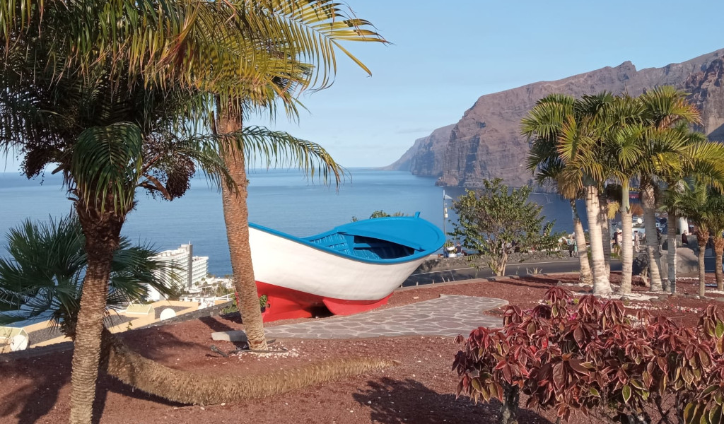 Blauw-witte boot in een park met uitzicht op Los Gigantes, Tenerife.