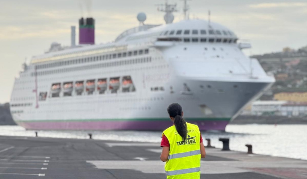 Persoon die een cruiseschip bekijkt dat aangemeerd ligt in de haven van Tenerife. Op het vest staat coördinator Tentravel.