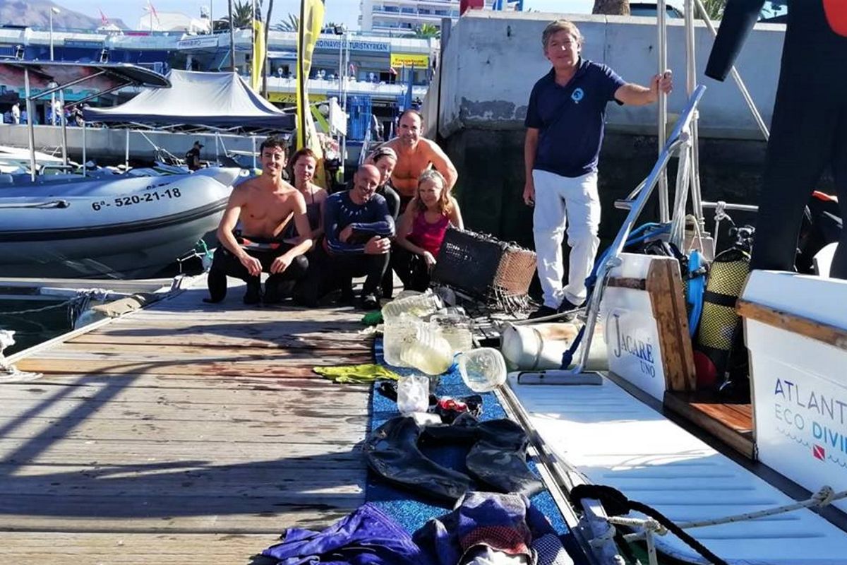 Mensen op de steiger met duikuitrusting en afval verzameld op Tenerife.